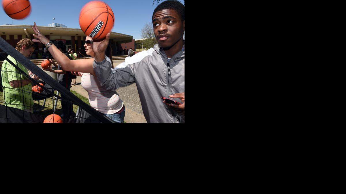 
Students Charles Williams and Tiffany Bolitho-Anderson shoot baskets while receiving text messages on Monday afternoon at Modesto Junior College. The California Office of Traffic Safety challenged students to do a timed basketball shooting contest while responding to text messages in order to warn them about the dangers of distracted driving.
