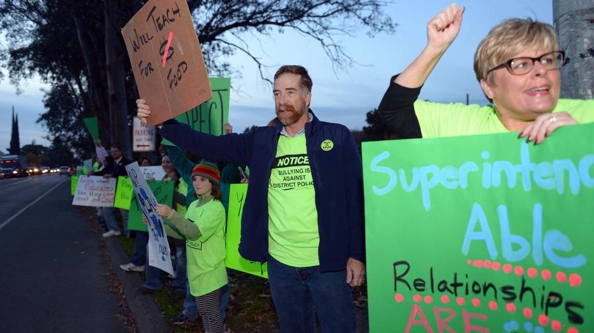 Jodie Hofkamp-Echol, right, and Curtis Johnson take part in a community protest rally by Modesto Teachers Association members Monday evening, Dec. 7, 2015, at Maze Boulevard and Martin Luther King Junior Drive. Hofkamp-Echol is a psychologist at Enochs High School and Johnson is a teacher at Hanshaw Middle School.