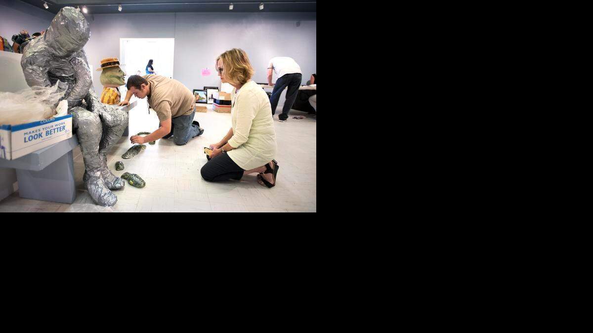 
Oakdale High art student Abel Torres drops off his ceramic sculpture Thursday as show organizer Vicky Boese, right, watches in preparation for the Youth Art Month art show for high school students at the Modesto Junior College Art Gallery in Modesto. The show opens March 21 and runs through March 26. Gallery hours are M-W 10-5, Sat-Sun 12-2.
