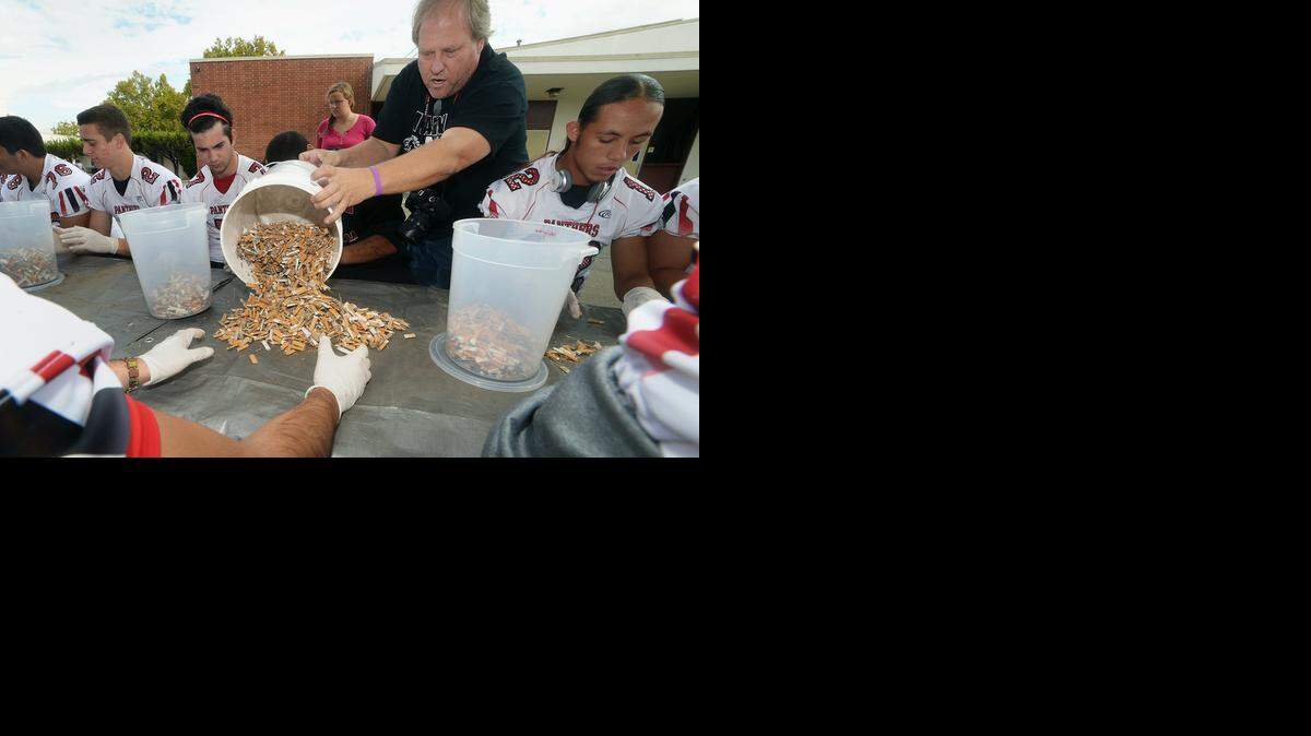 
Modesto High School photography instructor and PHAST club adviser Scott Mitchell pours out cigarette butts collected from East La Loma Park for counting, Friday, Oct. 31, 2014.
