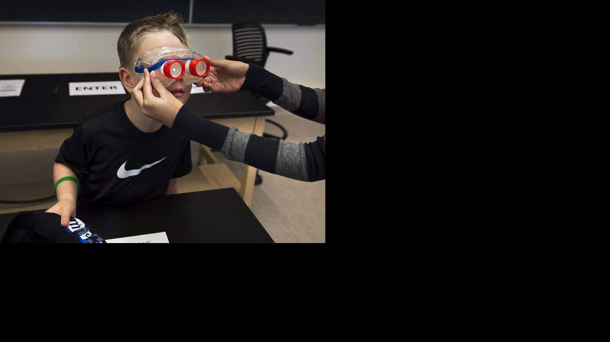 
Jadon Boyer looks through goggles that replicate the eyesight of insects with compound eyes during Science Day 2014 at California State University, Stanislaus, in Turlock.
