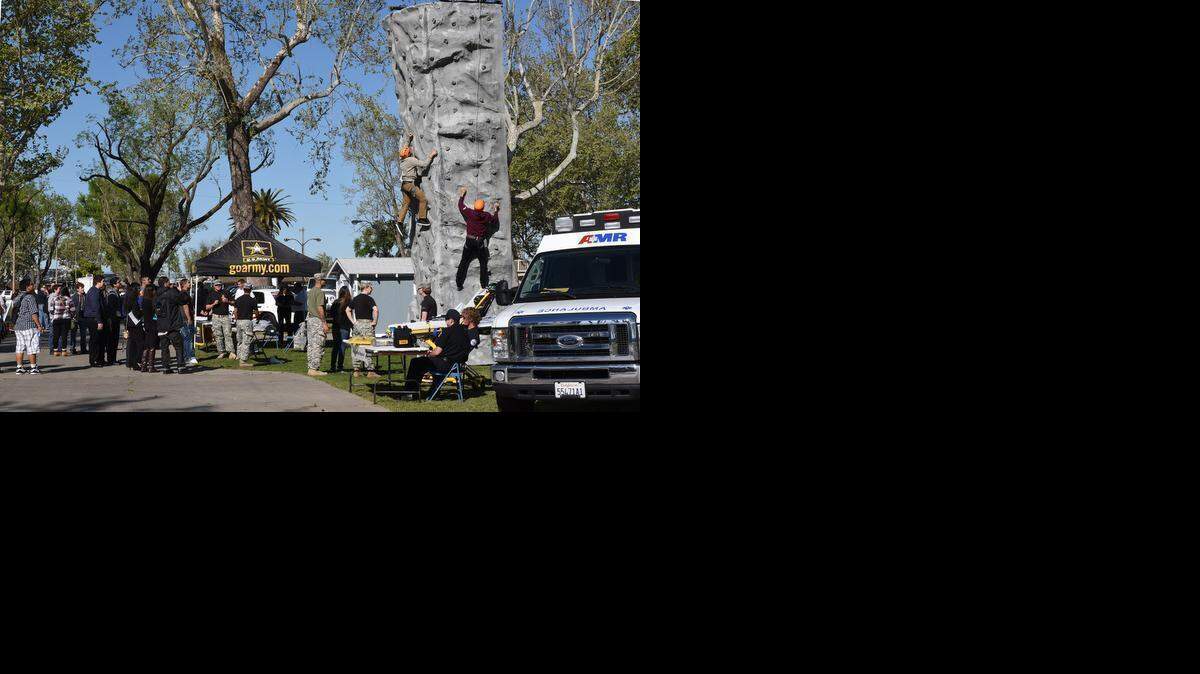 
Students climb a rock wall at the GoArmy.com station Wednesday morning  during the 30th annual Occupational Olympics at the Stanislaus County Fairground in Turlock.
