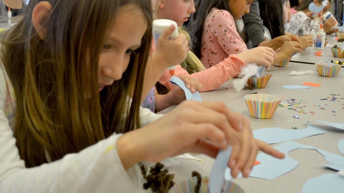 Children in the Medeiros Elementary after-school program, including Audrey Saavedra, left, create art projects with teens in the Pitman High School Art Club on Thursday, April 14, 2016.