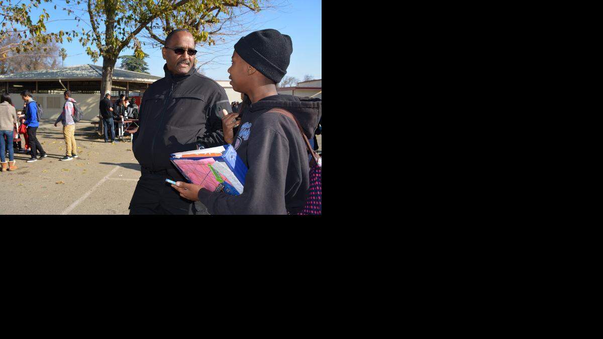 
School Security Officer Michael Joh son talks to junior Clyiesha Thigpen at Patterson High as he walks the campus during lunch Wednesday.
