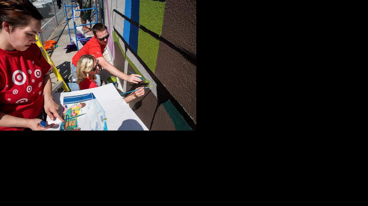 
Target store volunteers Katie Love, left, Kris Jackson and Kyle McCandless help paint a mural by artist Vince Cabrera at Fremont Elementary School in Modesto on Friday.
