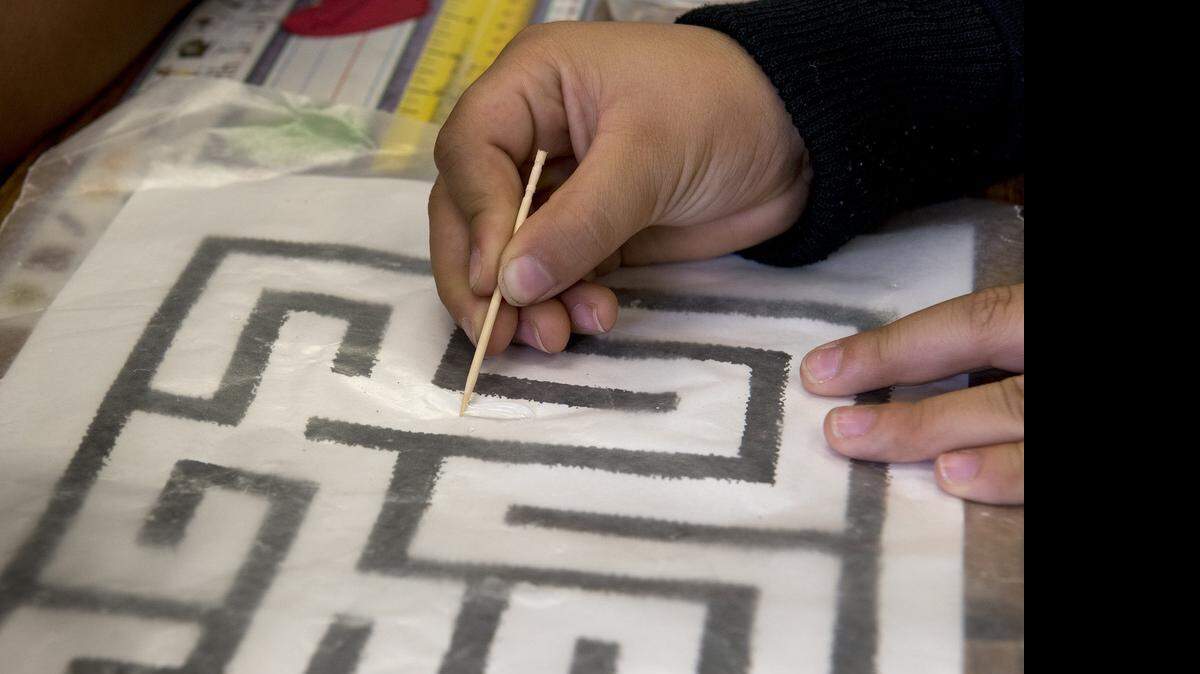 
First-grader Hector Flores Morales moves a water droplet along a maze laid under wax paper during the Science Ambassadors’ Science Lab at Franklin Elementary in Modesto on Friday.
