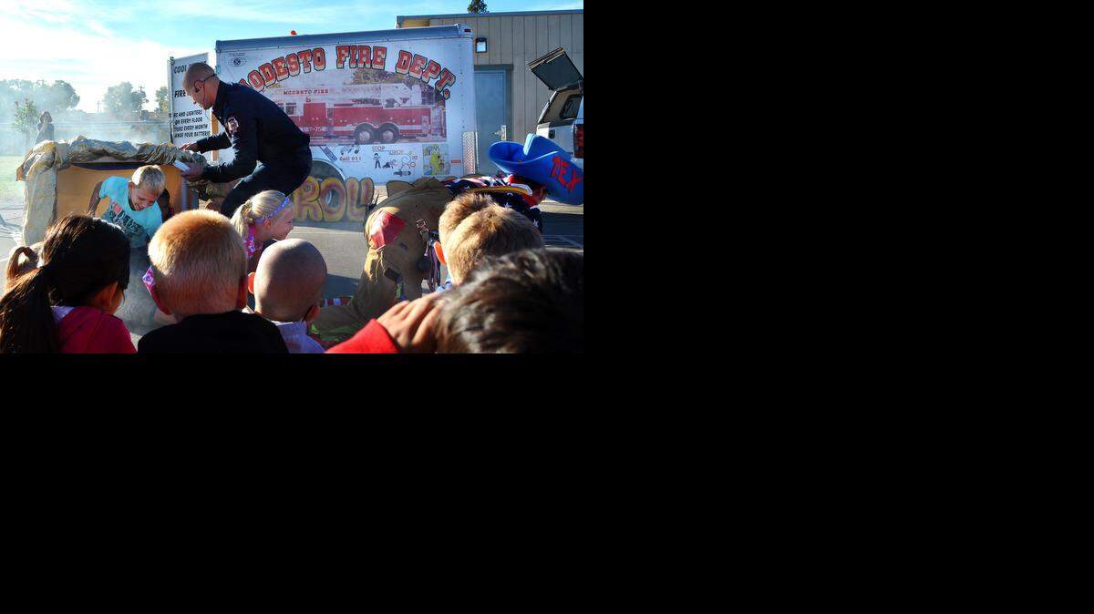 
Students crawl out of a “smoky hallway” behind Tex the Clown, right, portrayed by Modesto fire engineer Tommy Dick, and assisted by engineer Nick Clark during a safety assembly at Fremont Elementary in Modesto on Wednesday.
