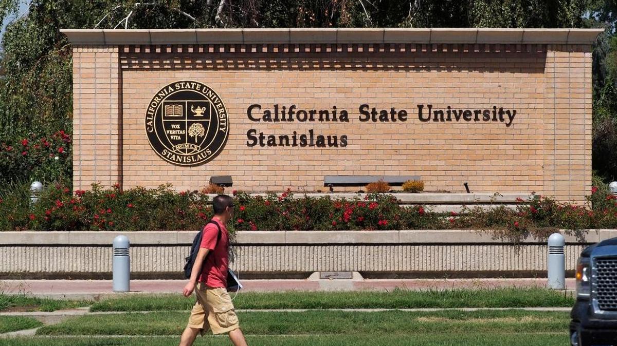 A student walks by the corner of Monte Vista Avenue and Geer Road in Turlock, the southeast corner of the California State University, Stanislaus, campus.