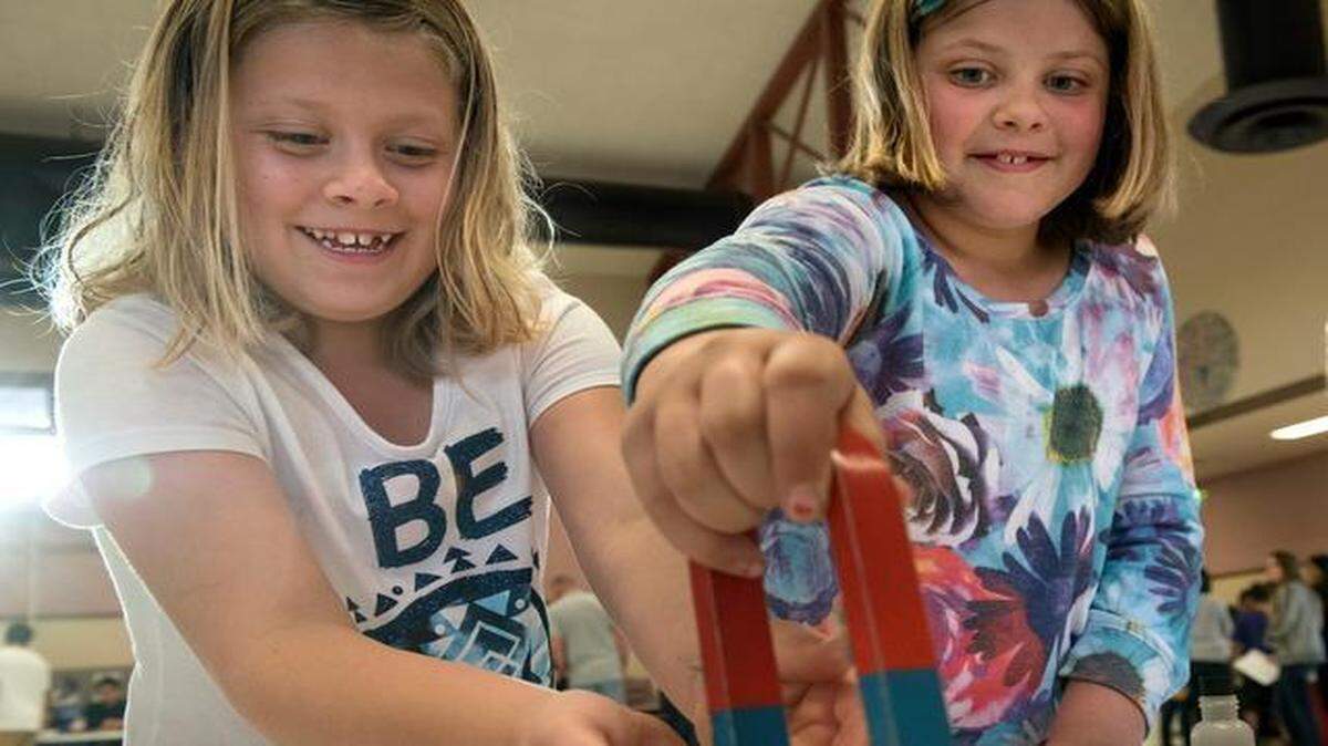 
Twin 9-year-old sisters Faith, left, and Rachel Hula experiment with magnets and metal shavings Thursday during Exploratorium Night at Johansen High School.
