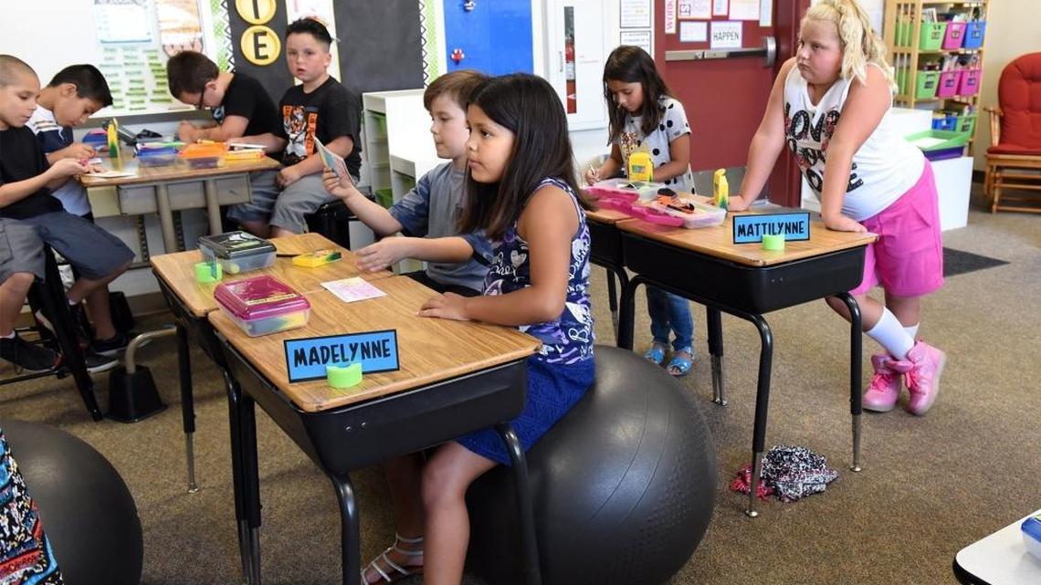 Third grader Madelynne Saragosa (center) uses a balance ball as Mattilynne Criswell stands at right Thursday (08-10-17) on the first day of school at Sylvan Elementary School in Modesto, Calif. The kids are offered alternative ways at desks for learning as part of the new STEAM program the school is launching this year.