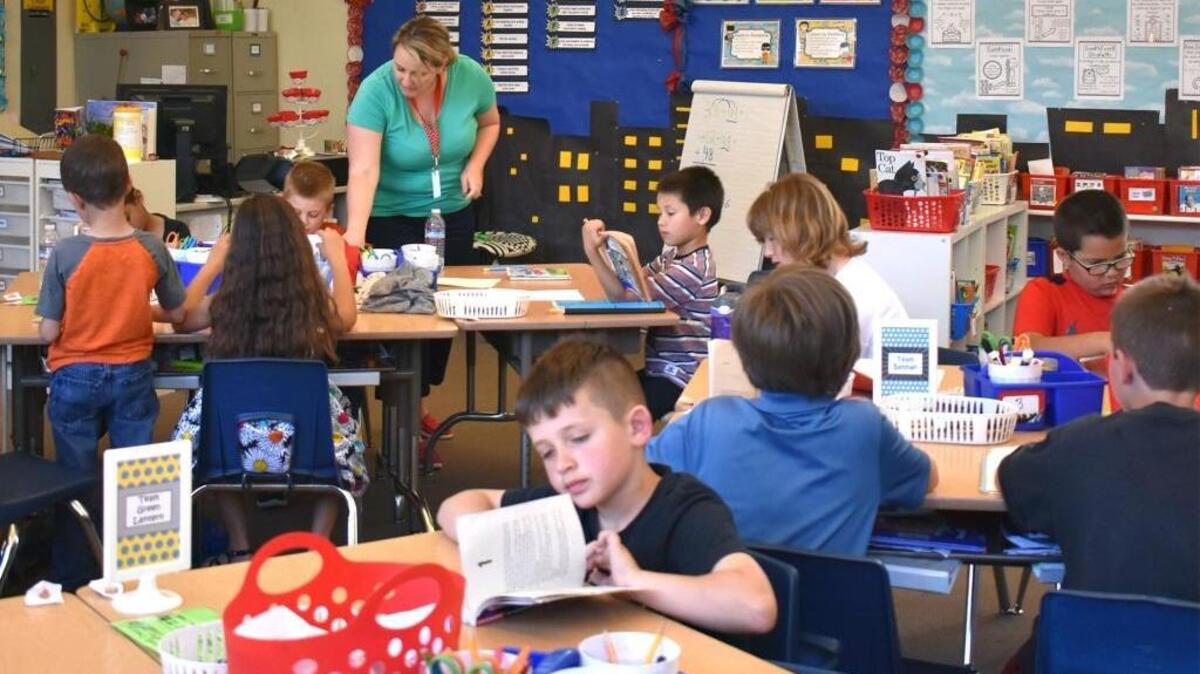 Second-grader Jacob Brummett, center, works on a reading assignment while teacher Amy Stevens,in background, helps another student in Enslen Elementary in Modesto, CA, on March 14, 2017. Enslen got a yellow for its English test scores in grades 3-6, and is targeting extra help to younger grades to make them stronger readers.