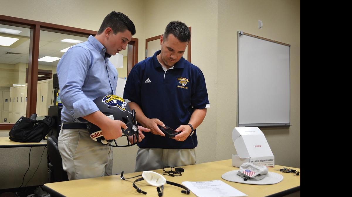 
Gregori High School sophomore Dominic Barandica, left, and head football coach Jason McCoy look at the Riddell Speed helmet, featuring InSite safety sensors, in August. Modesto City Schools trustees will vote Monday on buying them for all teams at all the district’s high schools.
