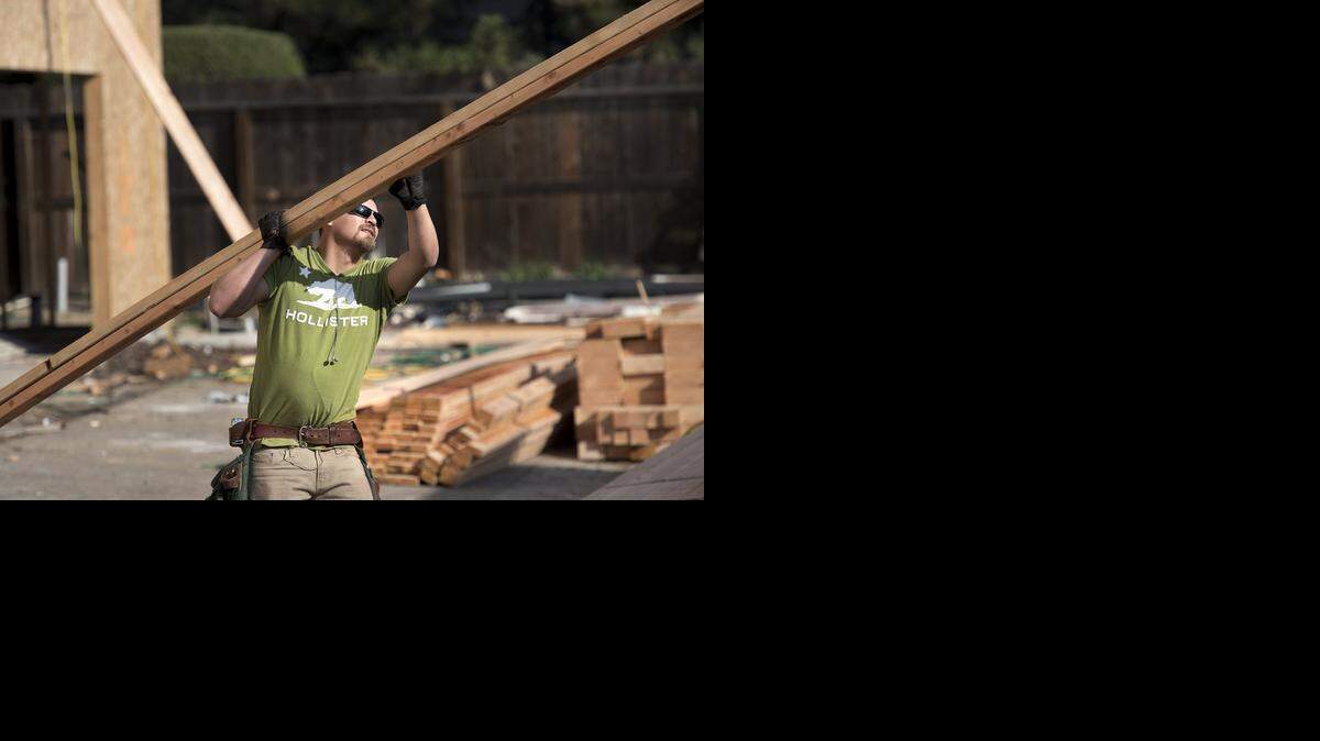 
Framer Mel Leyva from Leyva Construction stages lumber at the Avalon Townhomes project on Dels Lane in Turlock on Monday, February, 2, 2015.
