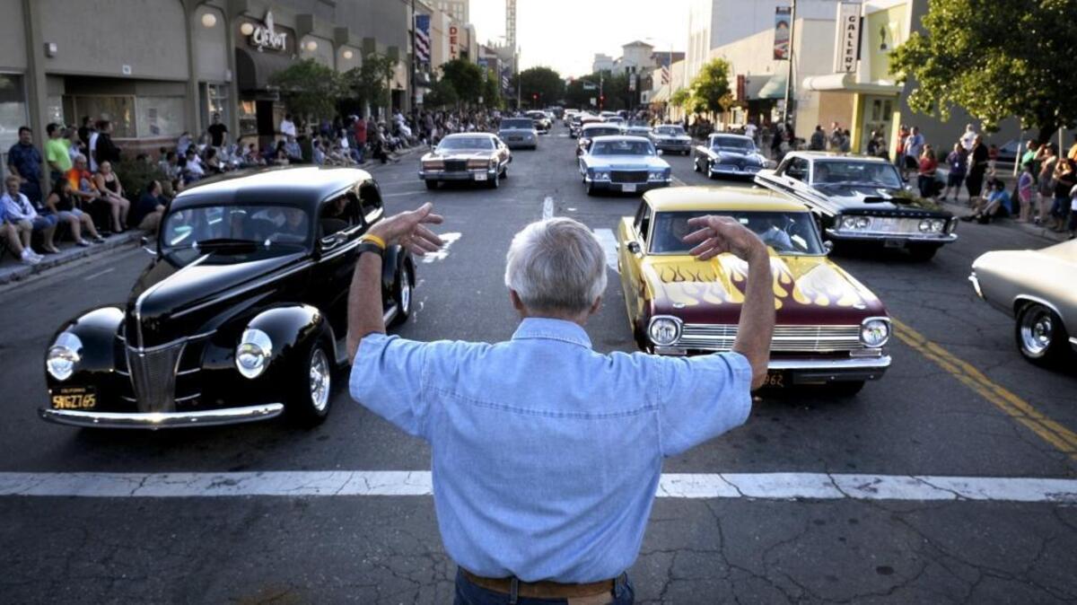 John Sanders controls traffic at 10th and I streets as hundreds of classic cars roll through downtown Modesto during the American Graffiti Car Parade in June 2011.