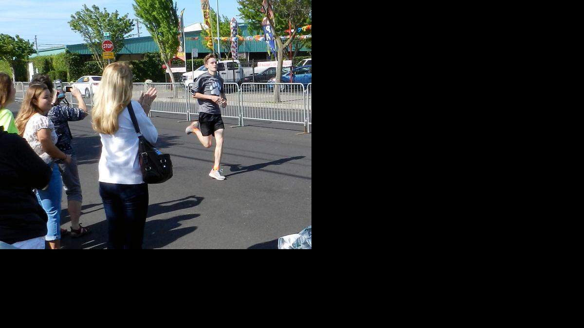 
Beyer High sophomore Jared Bingham crosses the finish line of the Modesto Marathon course on Saturday morning in downtown Modesto. The Teens Run Modesto participant ran the course a day early so that he could be in church Sunday morning.
