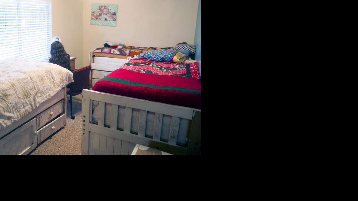
A teenager sits by a window in a bedroom with three beds at the open house for Hutton House on Jennie Street on Thursday. Hutton House is a state-licensed temporary shelter for runaway, homeless and youth in crisis, ages 13 to 17.
