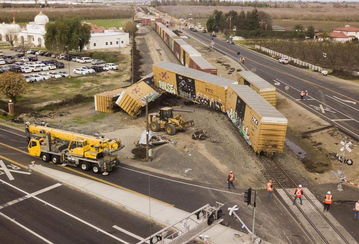 Crews work to clear and repair a section of Burlington Northern Santa Fe rail line at Hatch Road and Santa Fe Avenue north of Hughson, CA after a train derailment Sunday, Feb. 11, 2018.