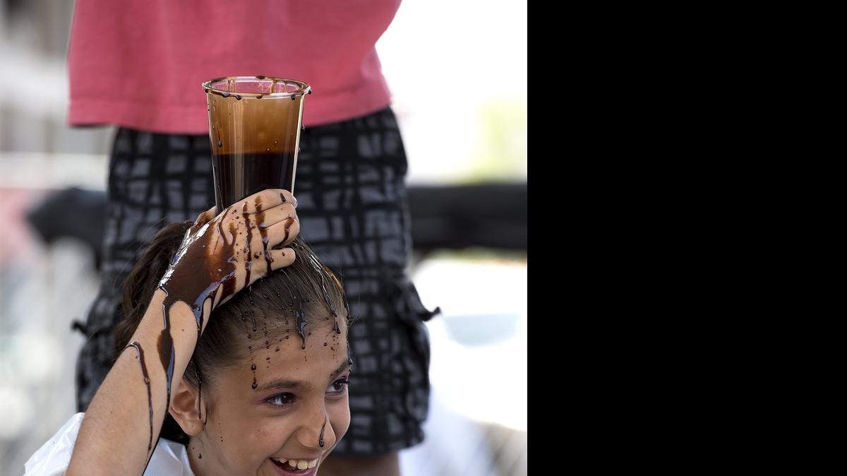 
Jade Fleming, 10, of Oakdale reacts as her brother Troy, 8, tries to fill a cup with chocolate syrup during a game on the Chocolate Challenge Stage at the Oakdale Chocolate Festival in Oakdale, Calif., on Saturday, May 16, 2015.
