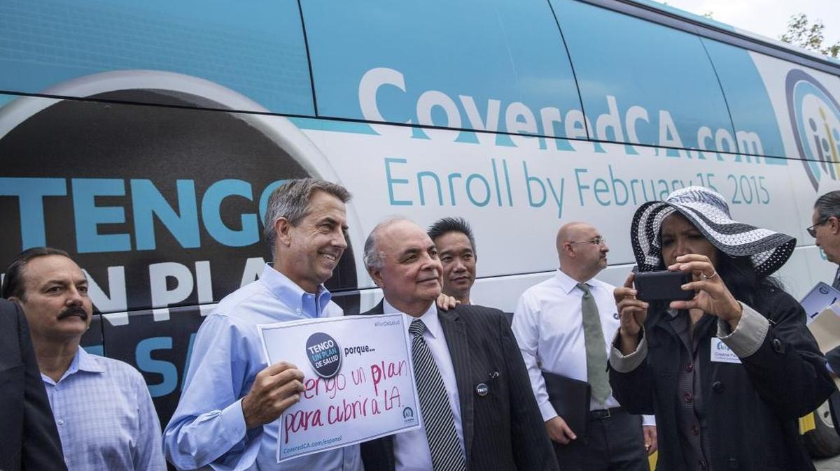 Peter Lee, second from left, the executive director of Covered California, poses with enrollees in the state-run health insurance exchange in front of Los Angeles City Hall in 2014.