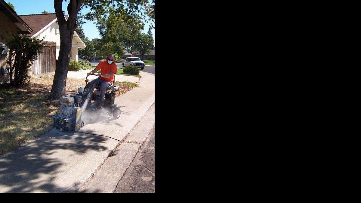 
Equipment operator Mark Ellis grinds down a sidewalk on Fara Biundo Drive in Modesto.
