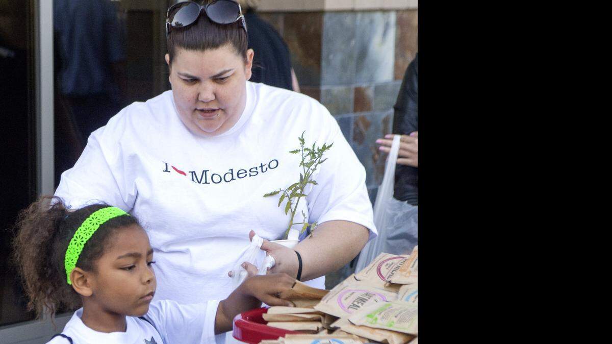 
Ekrister Aro and Leighla Aro pack food items in a bag for the Blessing in a Backpack tables during Love Modesto on April 18.
