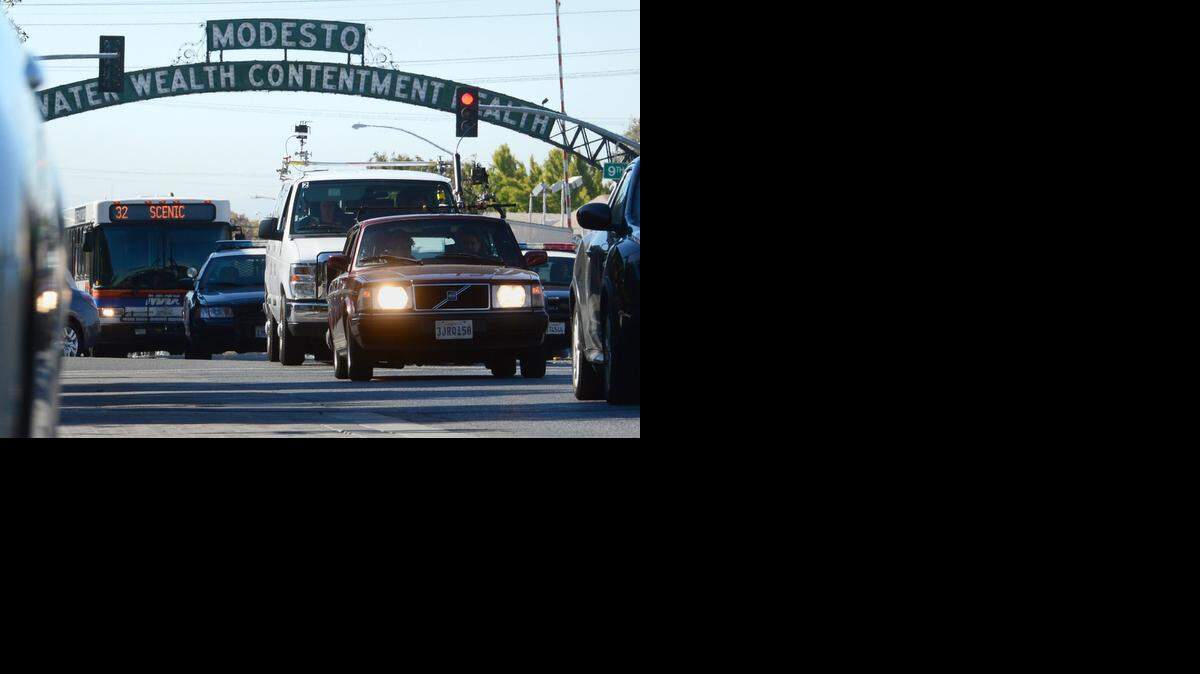 
The vehicle with lights on has actors and a camera as it films while traveling under the arch and surrounding area as HBO was in Modesto filming the TV show “Looking.”
