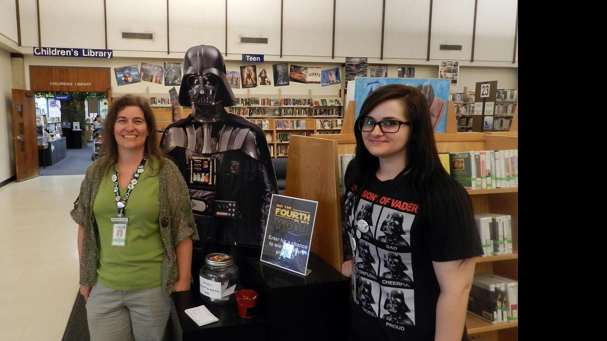 
 Amber O’Brien-VerHulst, left, and Michele Machado are library assistants in the children’s and teens department at the Stanislaus County Library in Modesto. The library is celebrating “Star Wars” week.
