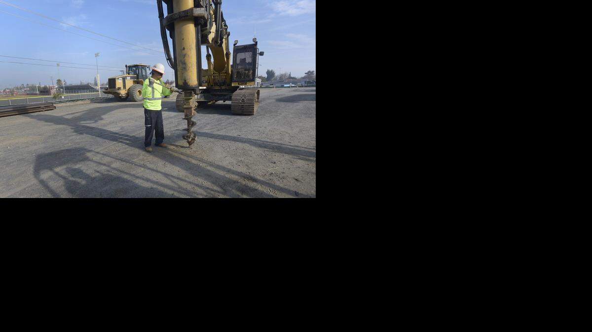 
Ricardo Garcia cleans the drill bit on an auger Thursday that will be used at the site for installing posts for a retaining wall and later to drill in the primary cleanup area off West J Street in Oakdale near Oakdale High School.
