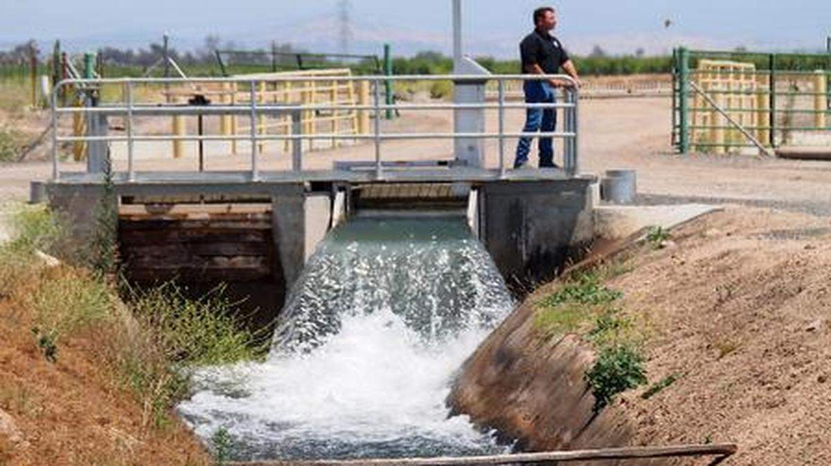 
Oakdale Irrigation District water passes through an automated flume gate as distribution operator Marc Oberkamper opens a slide gate to deliver water to fields in the Valley Home area in 2013.
