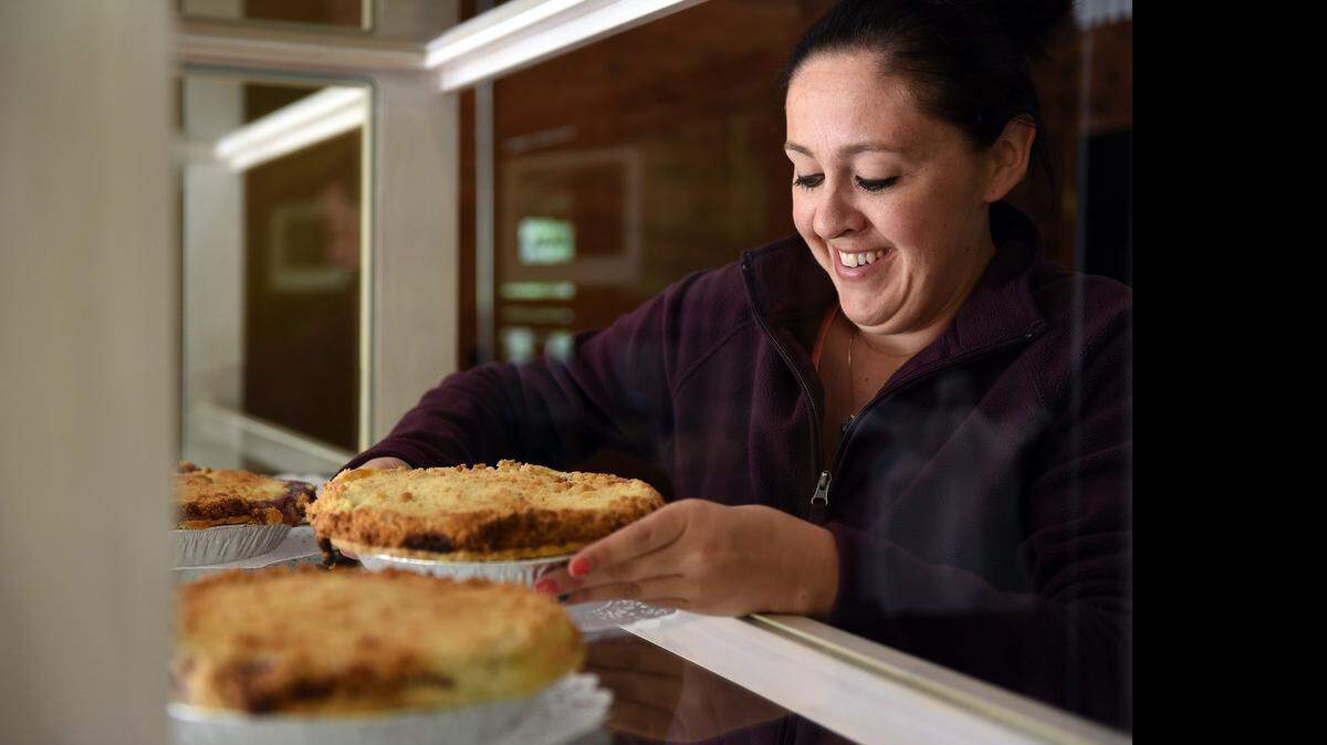 
Courtney Smith places pies in the display case Wednesday morning  at Bloomingcamp Ranch east of Oakdale.
