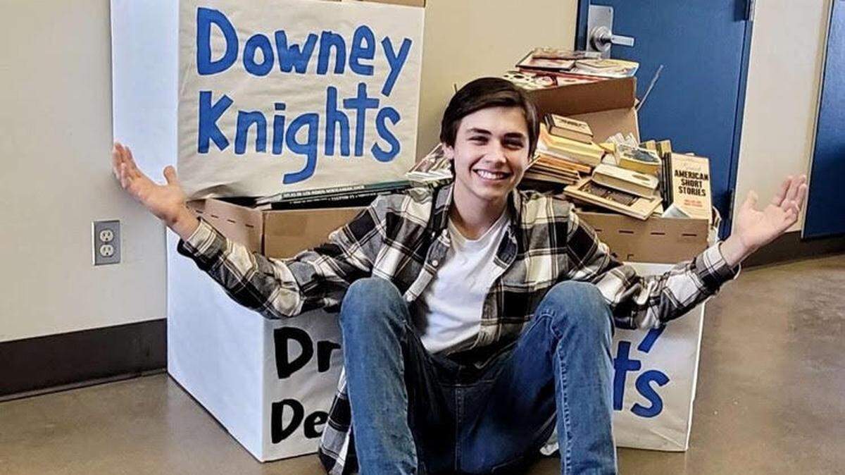 Student Body President Sethan Perez poses with some of the books collected at Downey High School for younger readers. Downey was one of seven taking part in a drive for the Reach Out and Read program in Modesto in December 2020.
