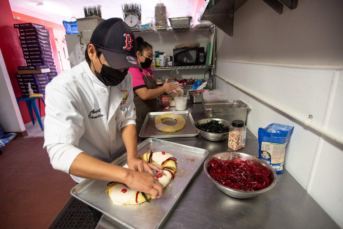 José Canseco decora el pan dulce navideño en Canseco's Bakery en Modesto, California, el miércoles 5 de enero de 2022. El personal ha estado ocupado atendiendo pedidos para el Día de los Reyes Magos.
