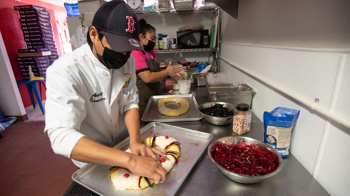 Jose Canseco decorates holiday sweet bread at Canseco’s Bakery in Modesto, Calif., on Wednesday, Jan. 5, 2022. The staff has been busy filling orders for Dia de Los Reyes Magos, Spanish for Three Kings Day.