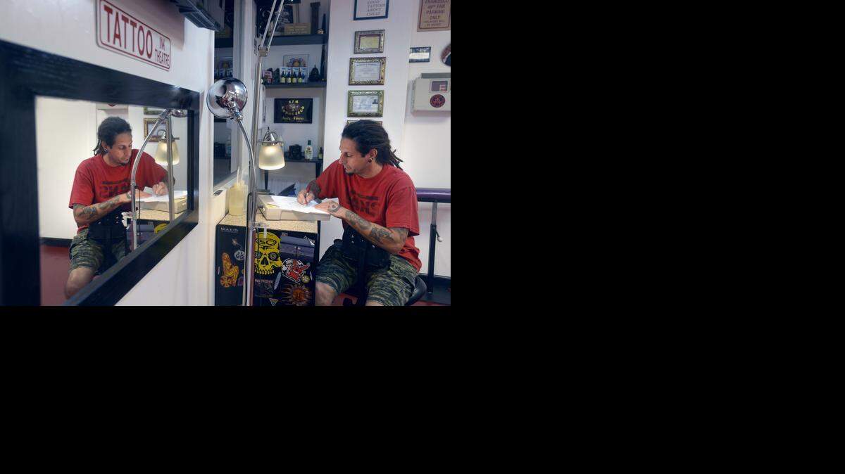 
Dano Friedman, owner of Soul Patch Tattoo in downtown Riverbank, works on a San Francisco Giants tattoo design he made for a client.
