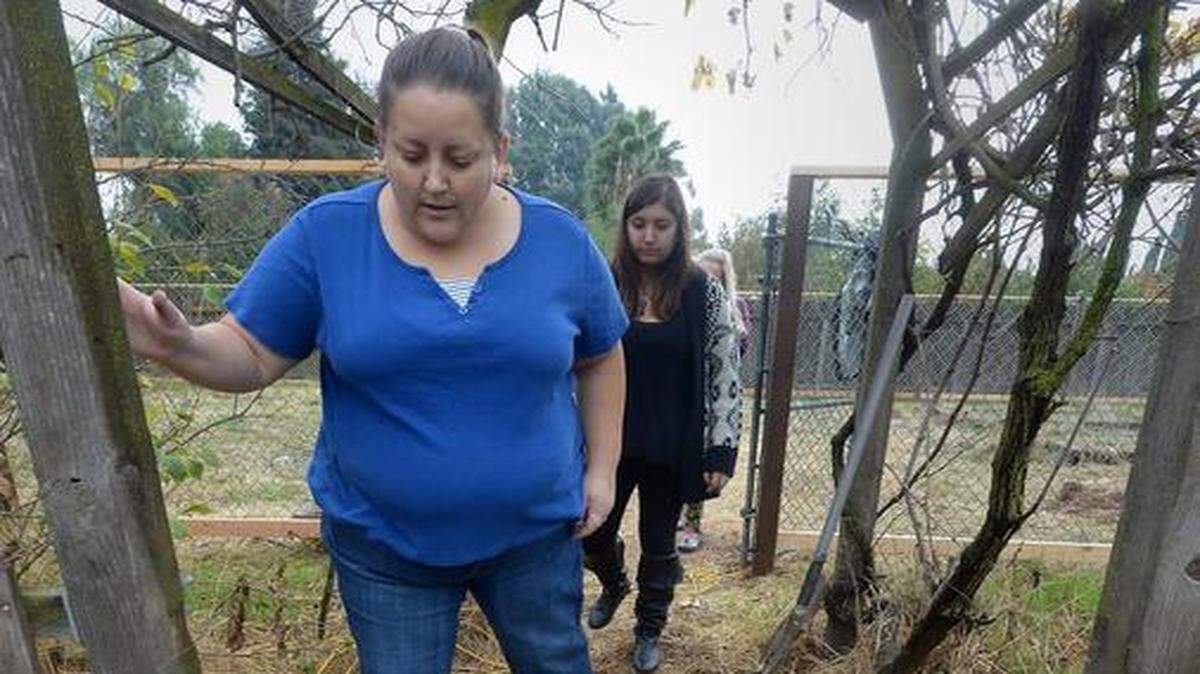 
Riverbank homeowner Amy Buenrostro, with daughter Ana behind her, stands over one of the headstones a previous owner had turned over and was using as a steppingstone.
