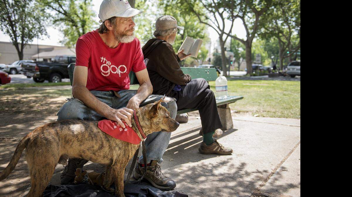 
Homeless resident Robert Berg sits with his dog, Ed, outside Ralston Tower in Modesto on Tuesday.
