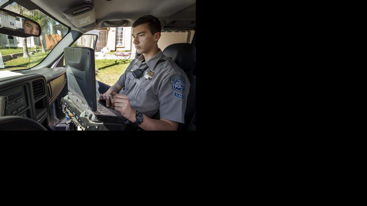 
Modesto police cadet Mike Fuzie checks the registration of a vehicle in southwest Modesto on Thursday.
