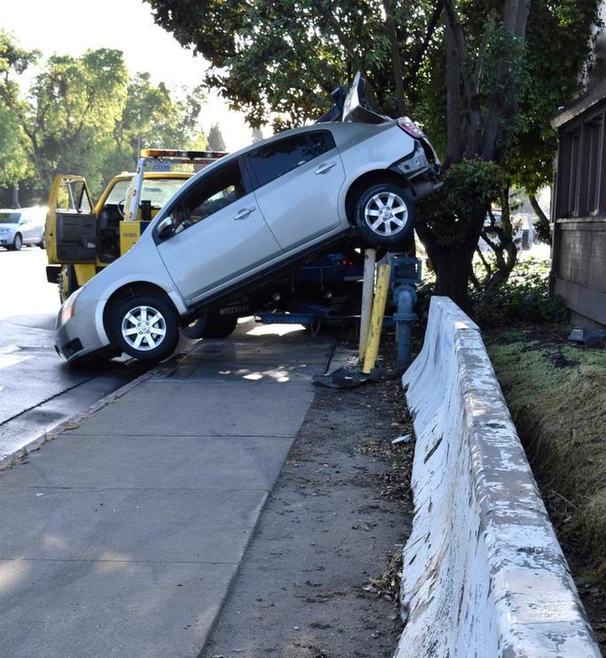 A driver was unhurt but had to be helped out of her car after she spun out on rain-slick Scenic Drive in January 2017, hit the curb and concrete barriers and ended up with the rear of her car stuck on pipes that protect a water backflow prevention assembly.