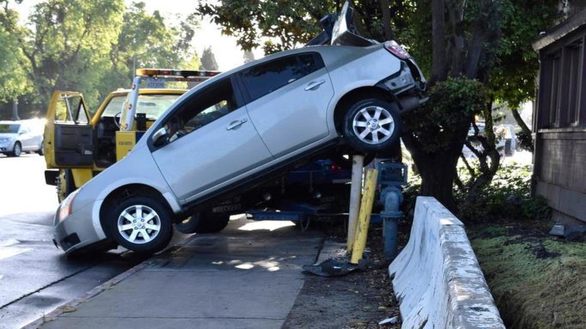 A driver was unhurt but had to be helped out of her car after she spun out on rain-slick Scenic Drive in January 2017, hit the curb and concrete barriers and ended up with the rear of her car stuck on pipes that protect a water backflow prevention assembly.