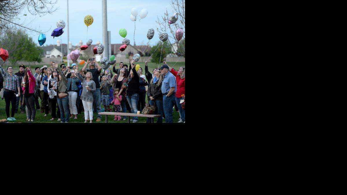 
Friends and family of Lauren London release balloons in her remembrance Friday at Leigh Bright Field in Hughson. London’s mother, Denise Donnell, stands at center holding a candle.
