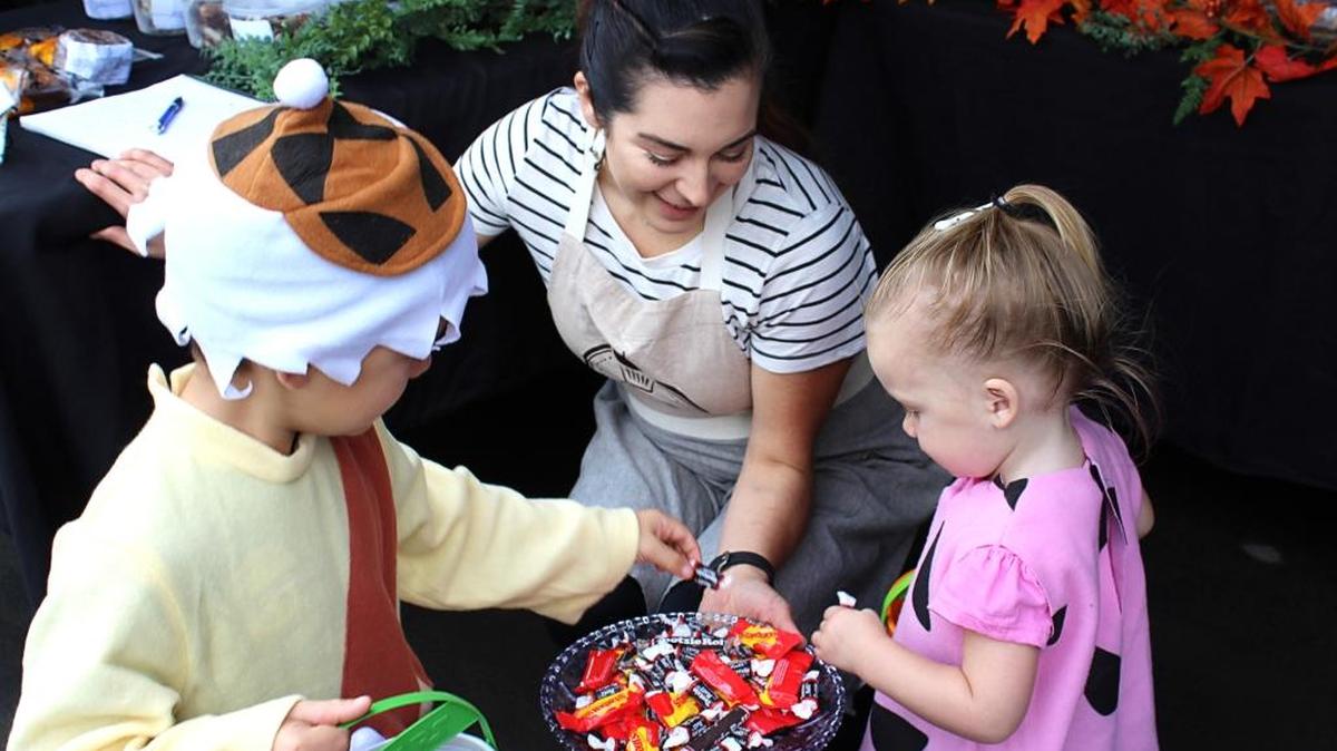 Vendor Chessie Garcia gives treats to the Flintstones – Bamm-Bamm (Terrell Estes, 6) and Pebbles (Kailey Estes, 2) – during the final Turlock Certified Farmers Market at the Stanislaus County Fairgrounds on Saturday, Oct. 29, 2016.