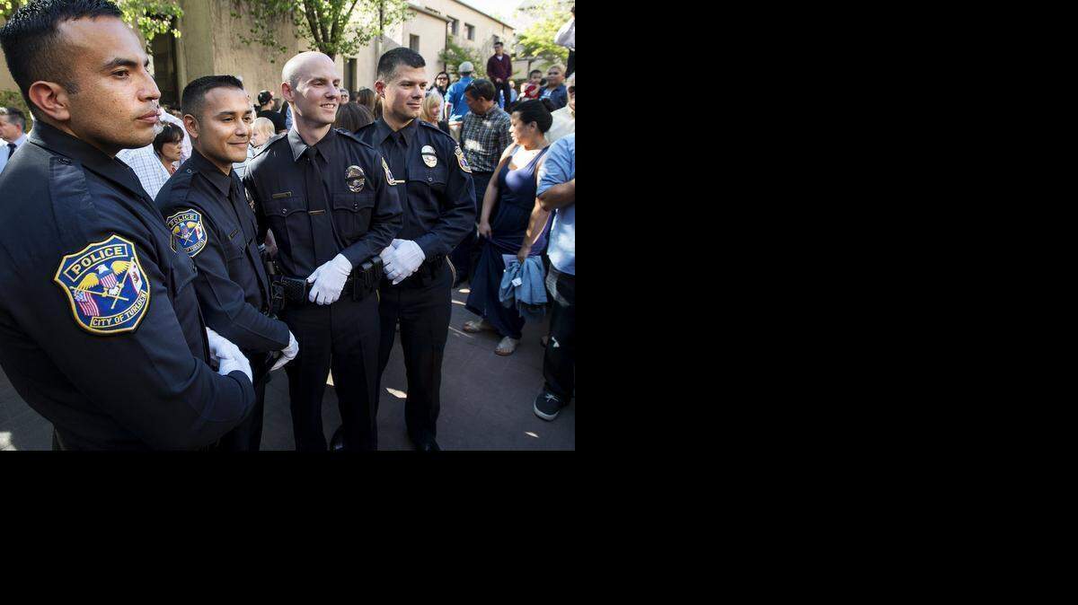 
New Turlock police officers, from left, Jose Calvache, Alfred Velasquez III, Adam Neep and Emanuel Moles pose for pictures after the San Joaquin Delta College Peace Officer Academy graduation ceremony at Delta College in Stockton on Wednesday.
