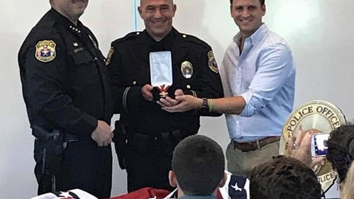 Turlock police Officer Paul Heppner, center, is honored May 30 by Chief Nino Amirfar, left, and Mayor Gary Soiseth.
