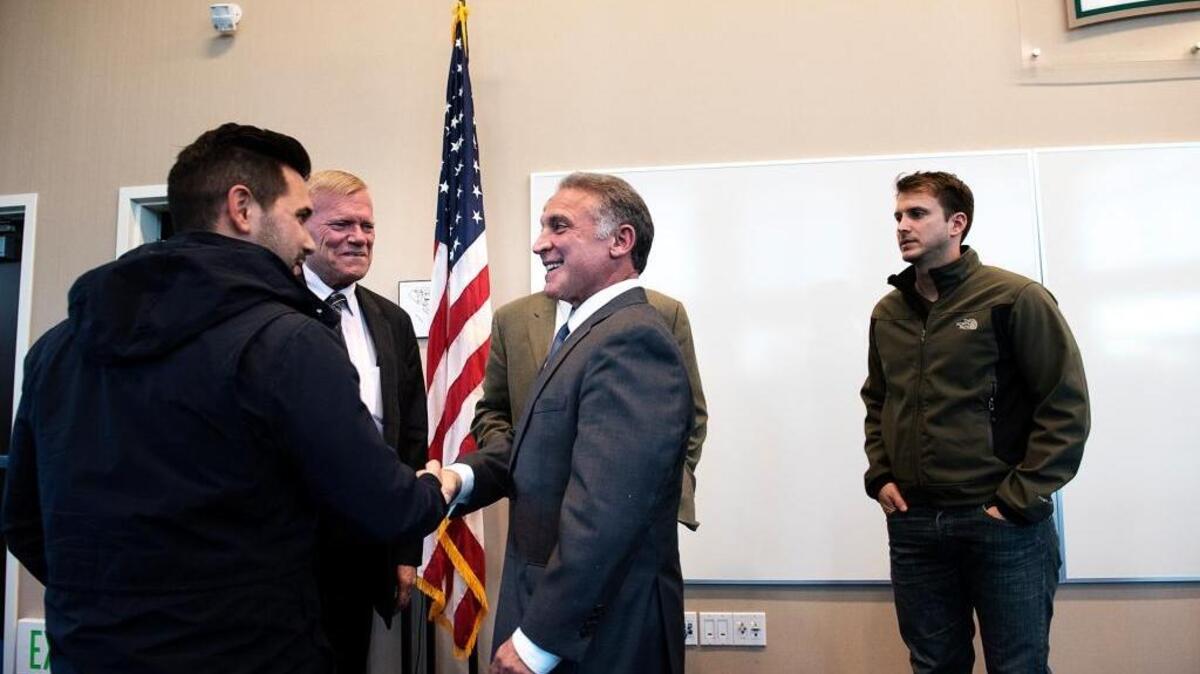 Newly hired fire Chief Robert Talloni, middle, greets Turlock council members Steven Nascimento, left, and Bill DeHart Jr. during a a community reception at the Turlock Public Safety Facility on Wednesday, Nov. 25, 2015.