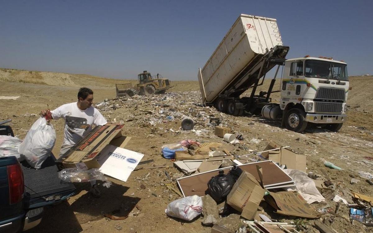 A customer throws garbage from the rear of his truck while a Turlock Scavenger garbage truck unloads at the Fink Road landfill in 2003, when the last Turlock trash fee hike passed.