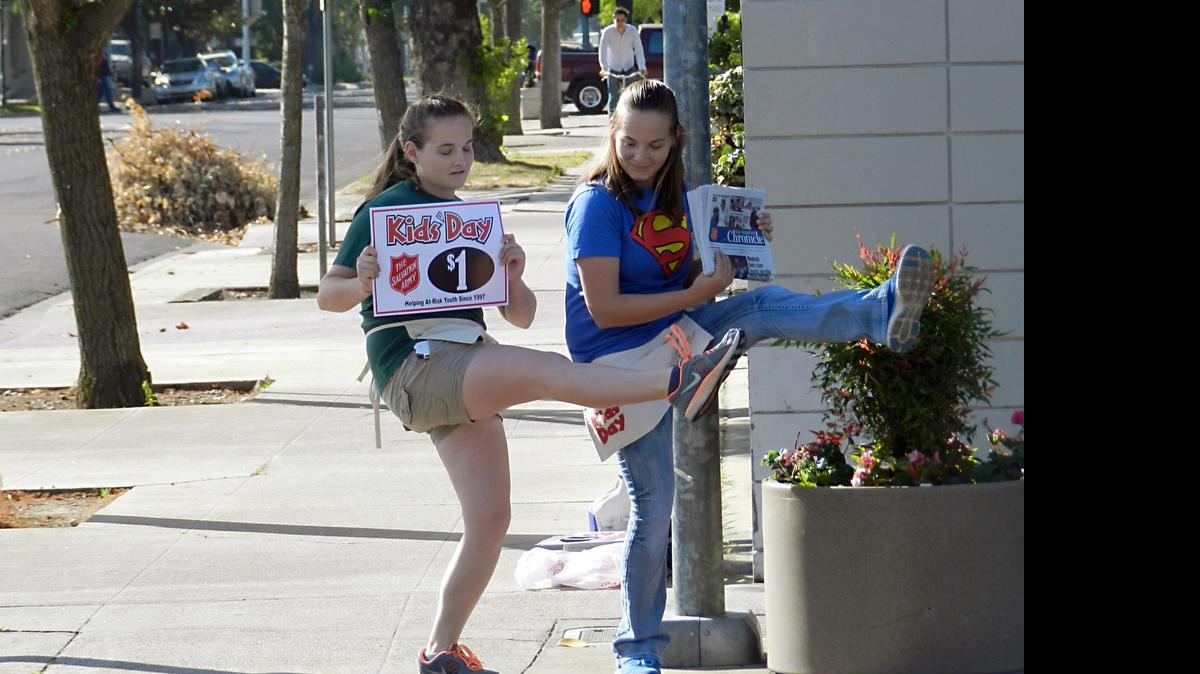 
Twins Emily and Claire Helm, students at Enochs High, sell newspapers during the Kidz Day fundraiser for the Salvation Army on Tuesday morning  at 14th and J streets in Modesto.
