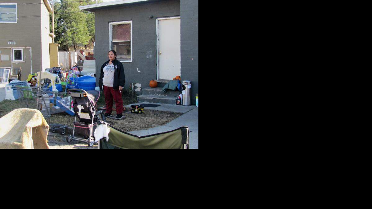 
Rosita Herrera, who lives in one of two of the occupied homes on Casa Blanca Court, watches firefighters train at one of the vacant homes. The entire court off Coolidge Avenue in Modesto is privately owned and a new property owner plans to refurbish the bungalows built in 1947. 
