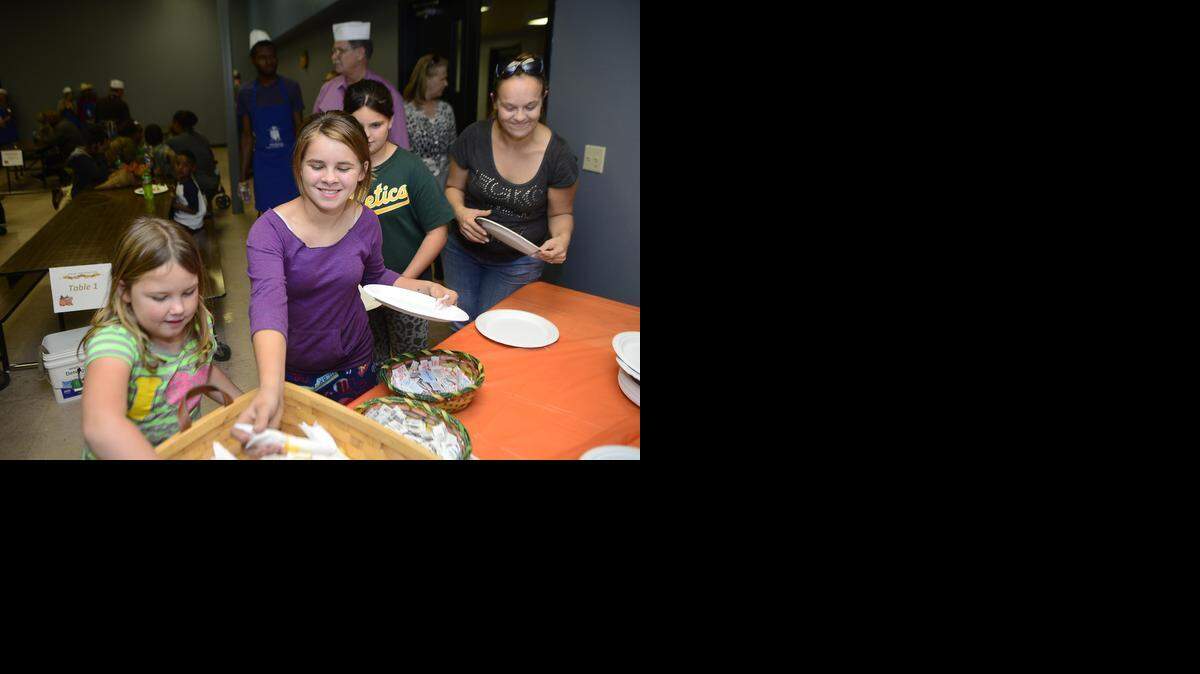 
From left, Emily Holly, 8, and Autumn Adkins, 12, collect their plates and silverware during the Modesto Gospel Mission’s annual Thanksgiving Banquet and Bundle Up on Wednesday (11-26-14).
