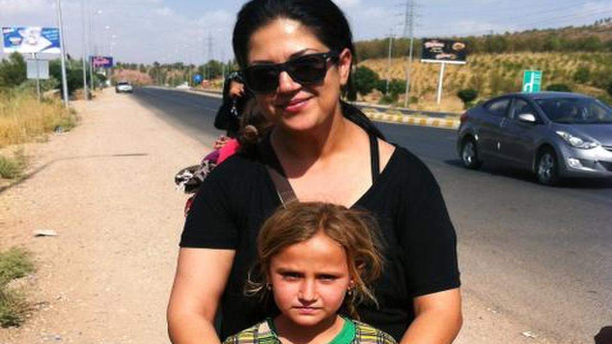 
Suzan Younan holds Suzan, whose cousins and sister were abducted by the Islamic State and sold as sex slaves. Suzan escaped and lives in a makeshift tent along the street in Dohuk, Iraq.
