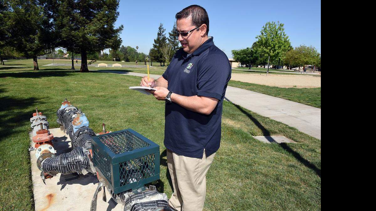 
Juan Tejeda, a water conservation specialist with the city of Modesto, takes a reading from the water meter at Charles M. Sharp Park in Modesto on Friday. 
